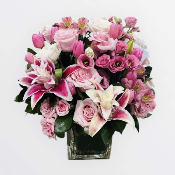 Pink and white mixed bouquet in a clear square vase