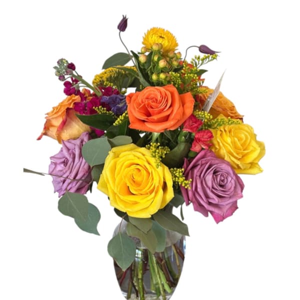 Colorful bouquet of roses and mixed flowers in a glass vase