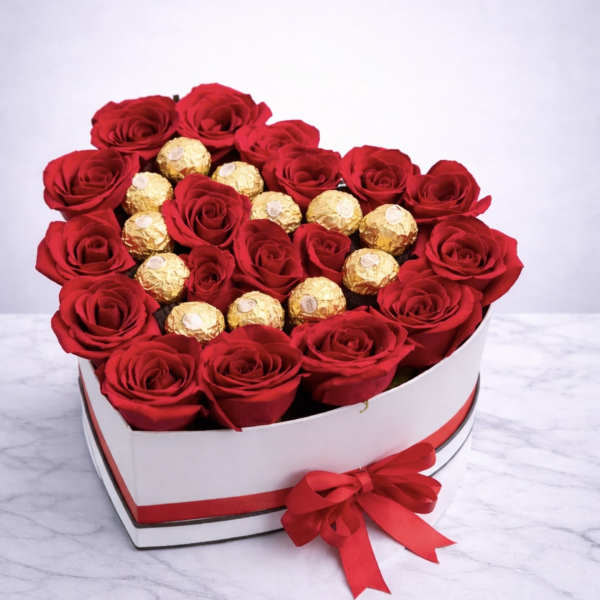 Heart-shaped box of red roses with gold-wrapped chocolates and a red ribbon