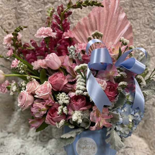 Pink roses and mixed flowers in a blue box with a ribbon