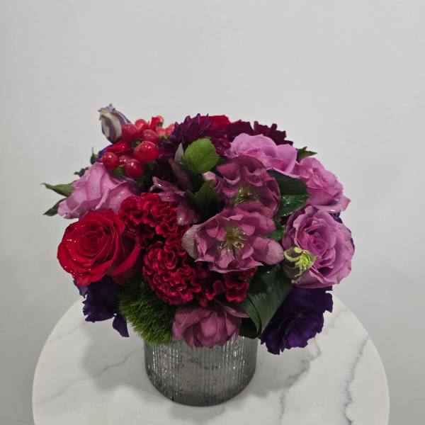 Mixed pink, red, and purple bouquet in a silver vase