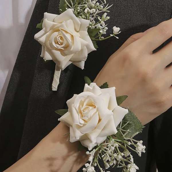White rose corsage and boutonniere with small white filler flowers