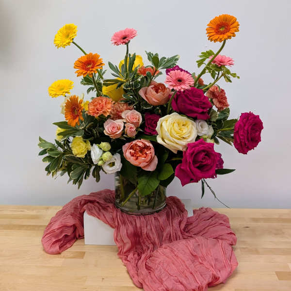Mixed bouquet of roses and gerbera daisies in a glass vase