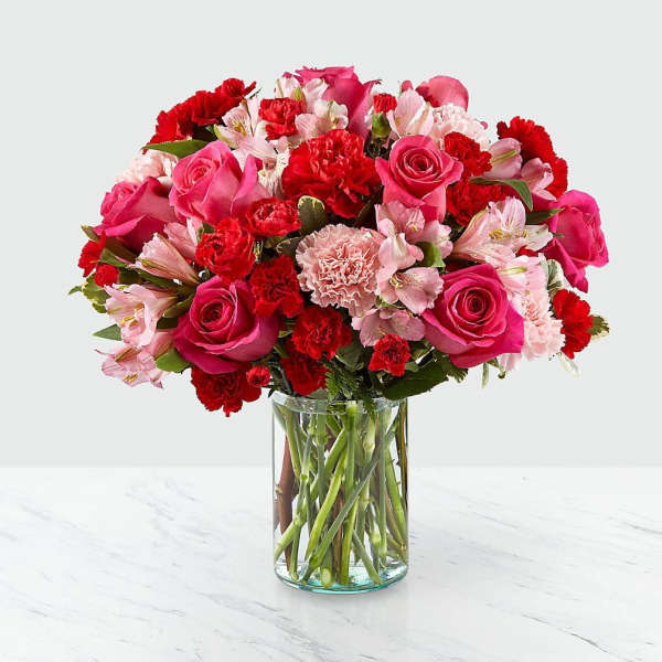 Pink and red mixed flower bouquet in a clear glass vase