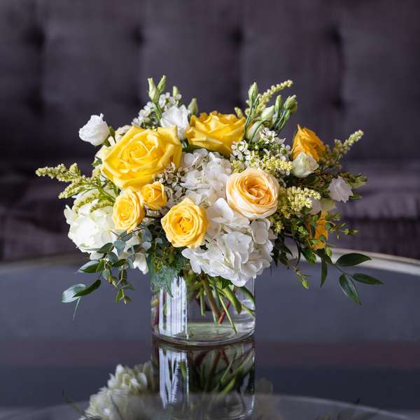 Yellow and white rose bouquet in a clear glass vase