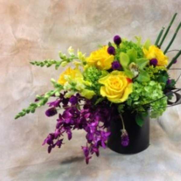 Yellow and purple floral arrangement in a black vase