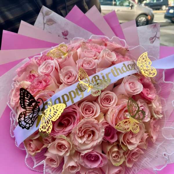 Pink rose bouquet with a birthday ribbon and butterfly decorations