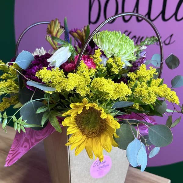 Sunflower bouquet with yellow and purple flowers in a gift bag