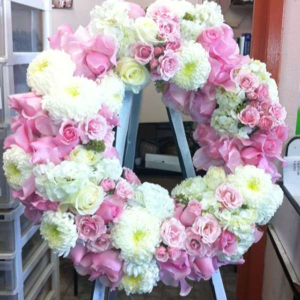 Pink and white floral wreath on a stand