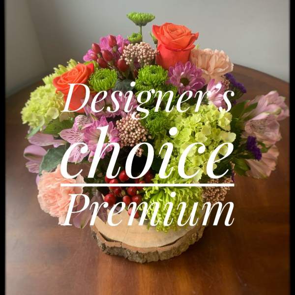 Mixed bouquet in a wood slice base with pink, orange, and green blooms
