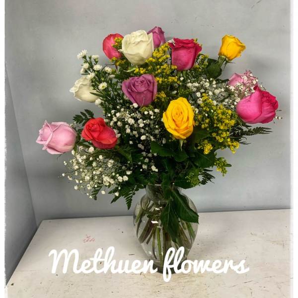 Mixed roses in a clear glass vase with baby's breath