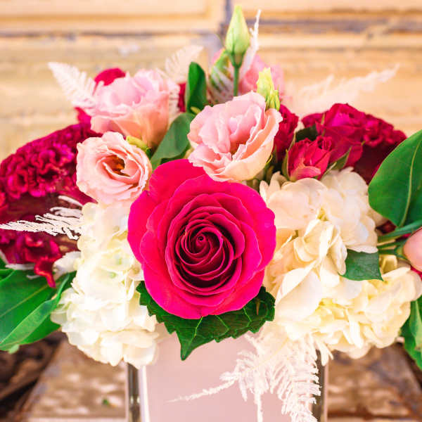 Pink and white floral arrangement in a square vase