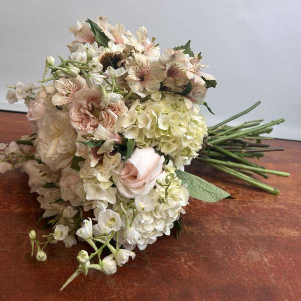 Bouquet of pale pink and white flowers on a wooden surface