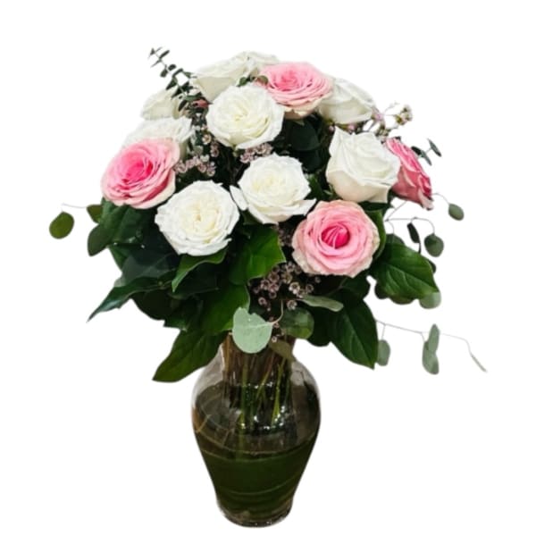 Pink and white roses arranged in a glass vase