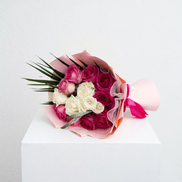Bouquet of pink and white roses wrapped in pink paper
