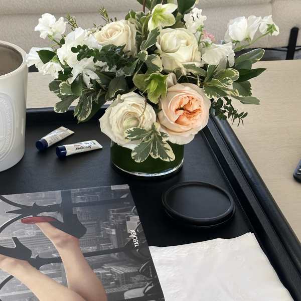 White and peach roses arranged in a low glass vase