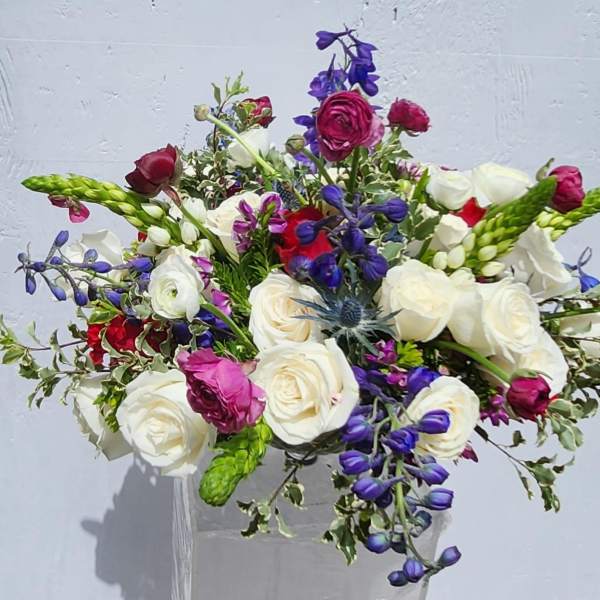 Bouquet of white, pink, and purple flowers in a clear vase