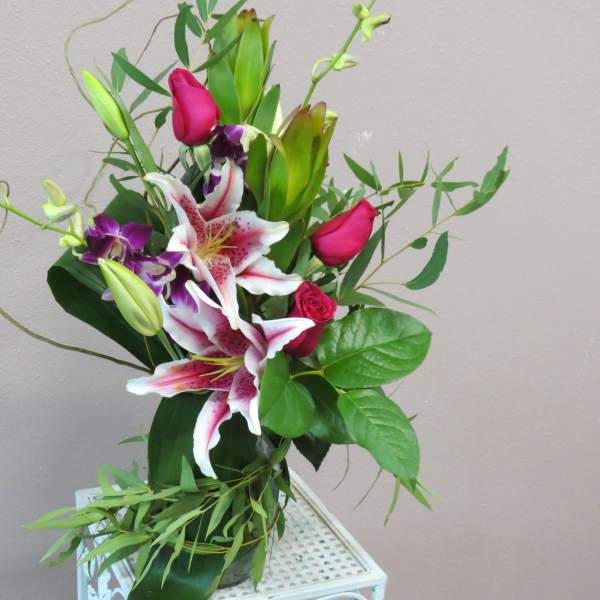 Bouquet of pink roses and white lilies with purple orchids