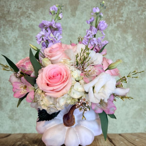 Pink and white floral arrangement in a white pumpkin container
