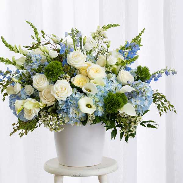 Blue and white floral arrangement in a white pot
