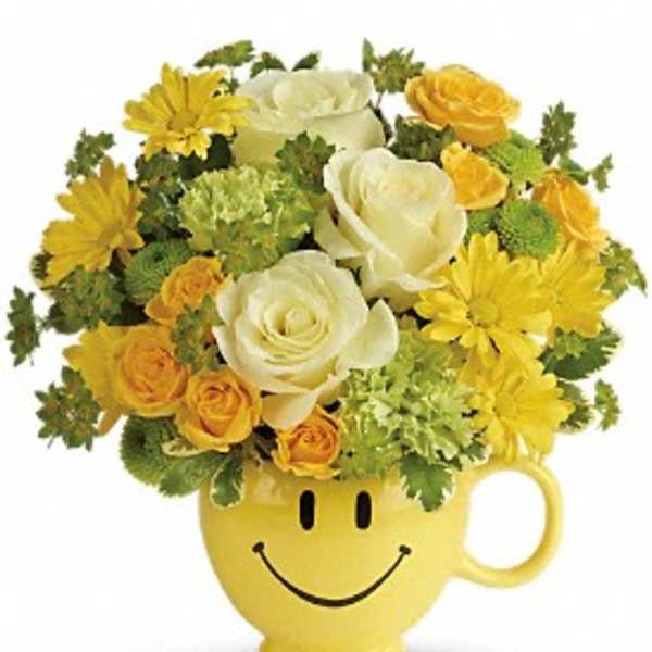 Yellow smiley-face mug holding white and yellow flowers
