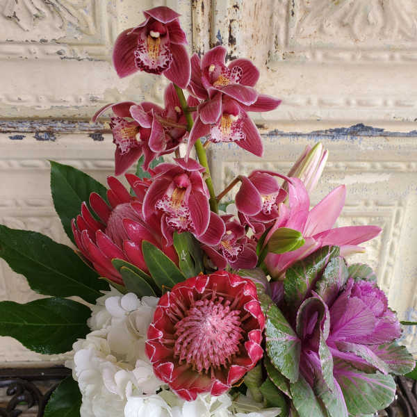 Pink orchids and mixed blooms arranged in a compact bouquet