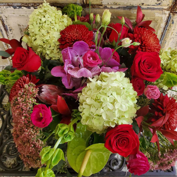 Bouquet of red roses, pink orchids, and pale hydrangeas
