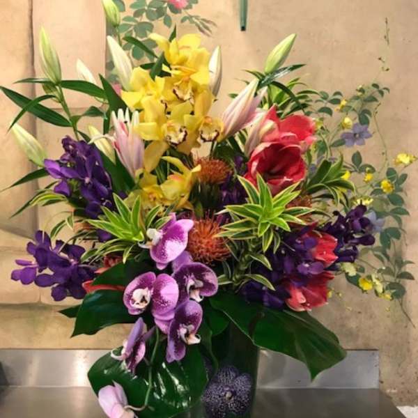Colorful orchid and lily arrangement in a clear glass vase