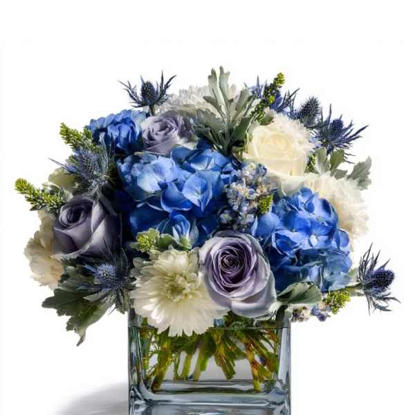 Blue and white flower arrangement in a square glass vase