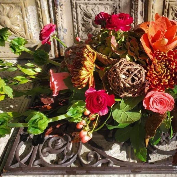 Mixed bouquet with orange, pink, and red flowers and greenery