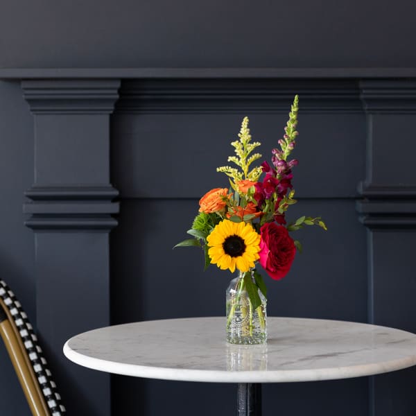 Mixed bouquet in a clear glass vase on a round table