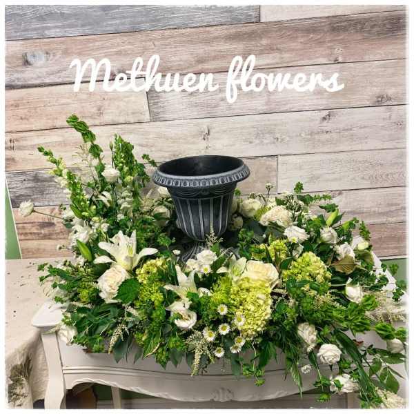 White and green floral arrangement around a black urn centerpiece