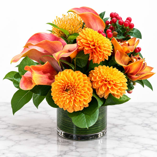 Orange and pink floral arrangement in a glass vase