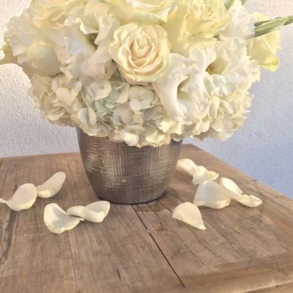 Cream rose and hydrangea arrangement in a textured silver vase