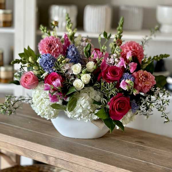 Mixed bouquet in a white bowl vase with pink, white, and purple flowers
