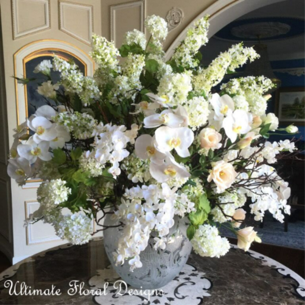 Large white floral arrangement in a decorative vase