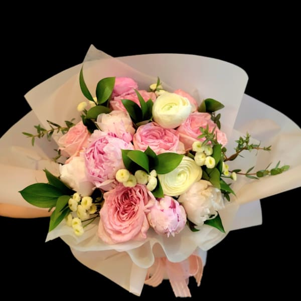 Pink and white bouquet of roses and peonies wrapped in white paper