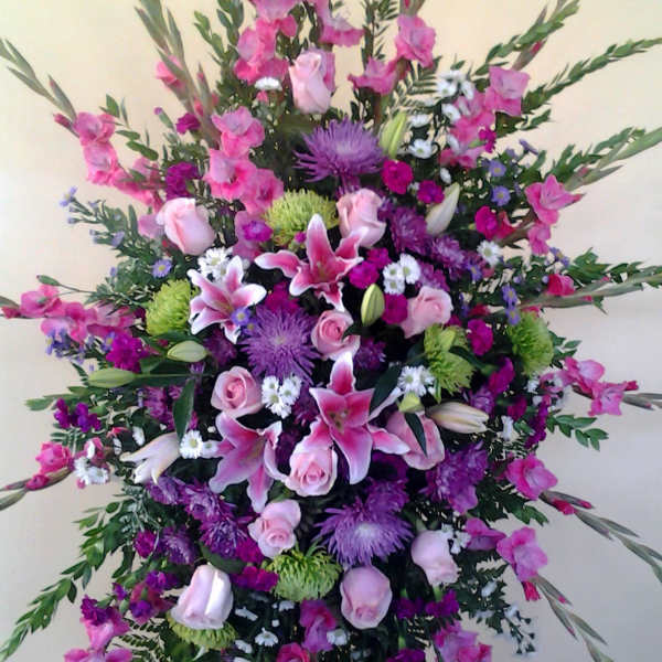 Large standing spray of pink and purple flowers on an easel