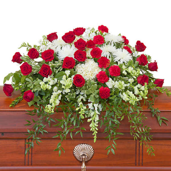 Red roses and white flowers arranged on a casket
