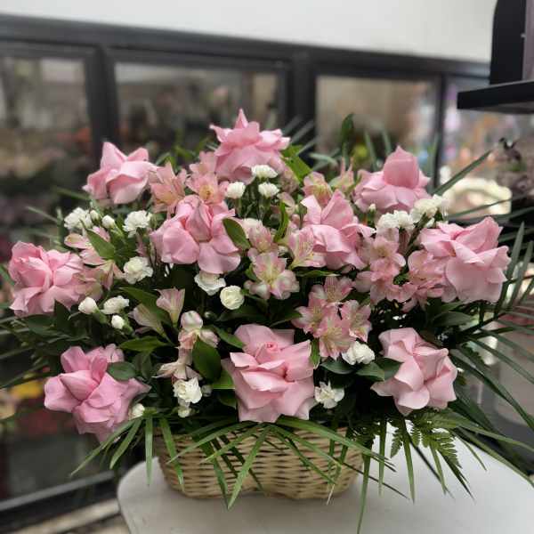 Pink roses and white filler flowers in a wicker basket