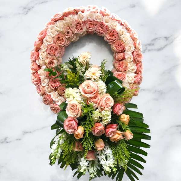 Pink and cream rose floral wreath with a matching bouquet at the base