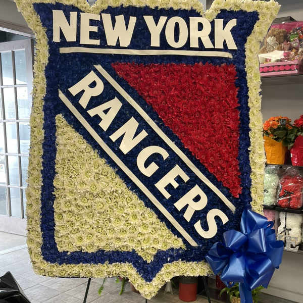 Large floral tribute sign reading NEW YORK RANGERS with blue and red flowers.