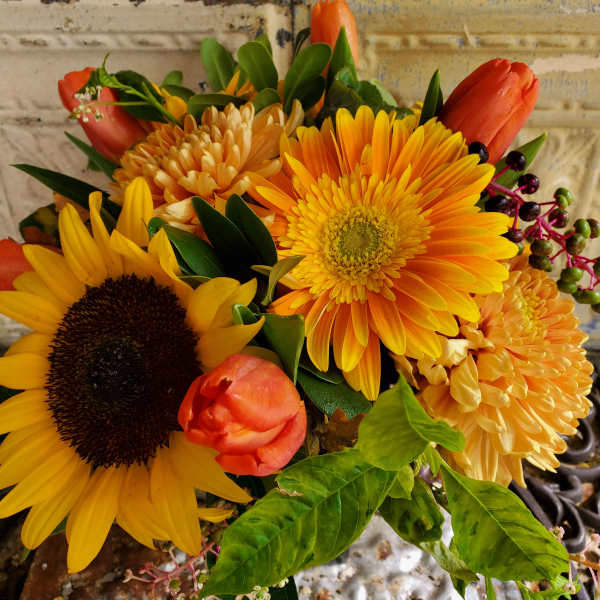 Bouquet of yellow sunflowers, orange tulips, and orange mums