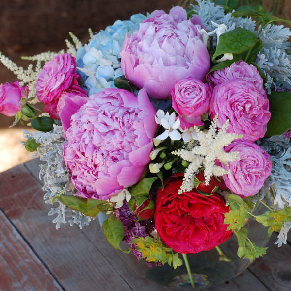 Pink and lavender bouquet with red roses in a glass vase
