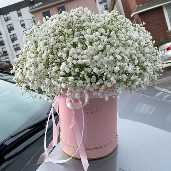 White baby's breath bouquet in a pink hat box with ribbon