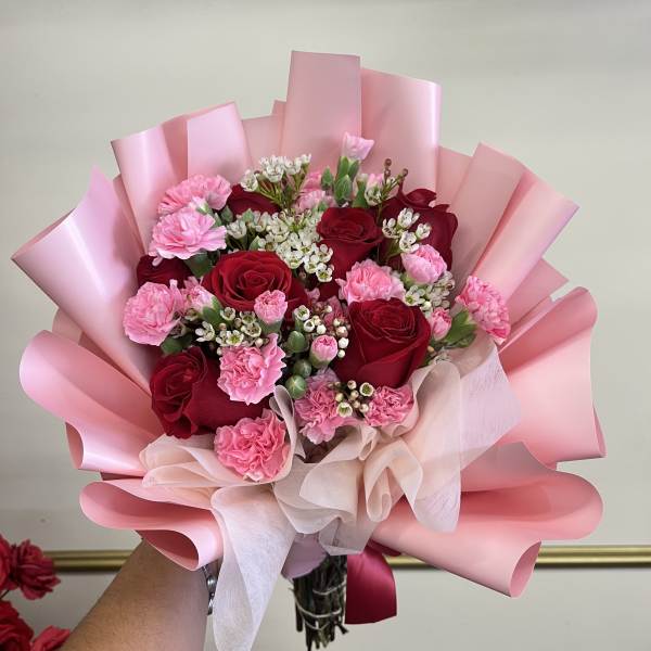 Pink and red rose bouquet with carnations wrapped in pink paper