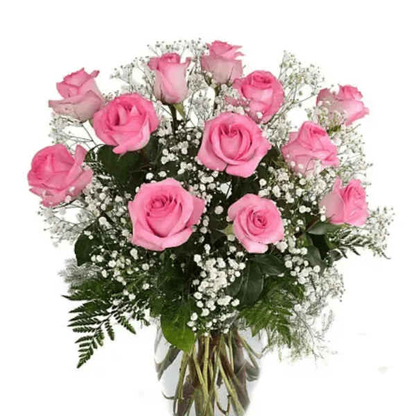 Pink roses arranged in a clear glass vase with baby's breath
