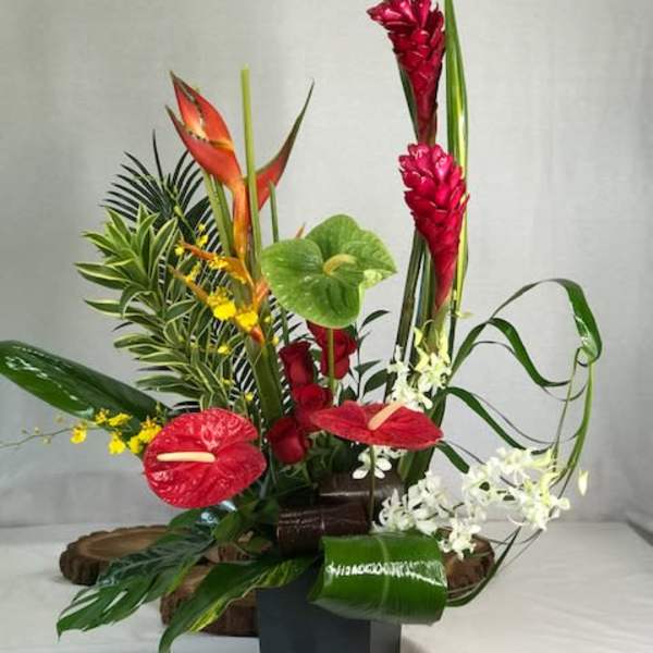 Tropical floral arrangement with red anthuriums and tall red ginger blooms