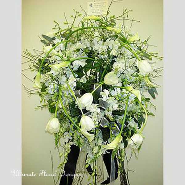 Tall white floral arrangement with arching stems and hanging blooms