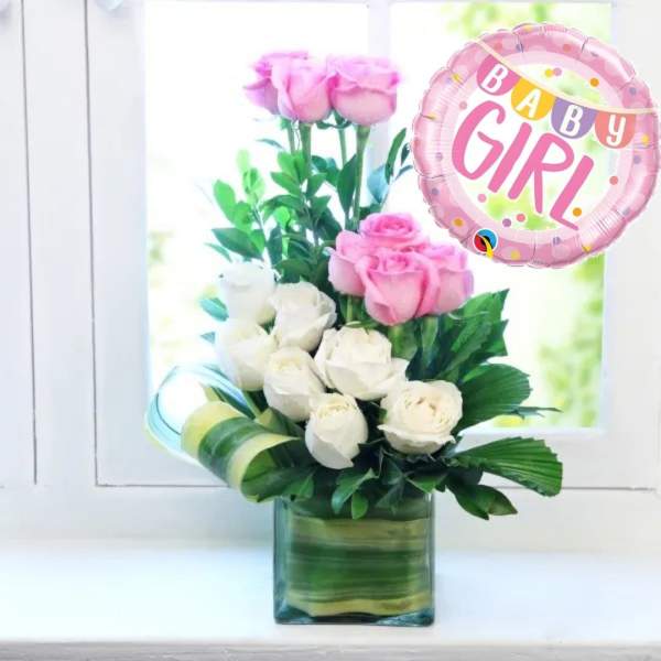 Pink and white roses in a square glass vase with a pink 'Baby Girl' balloon.